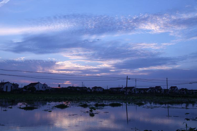 L'étang de lotus et le village chinois au coucher du soleil