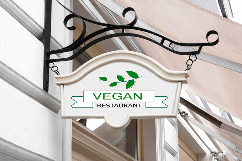 Vektor logo Vegán az étteremben, fehér alapon zöld levelekkel
